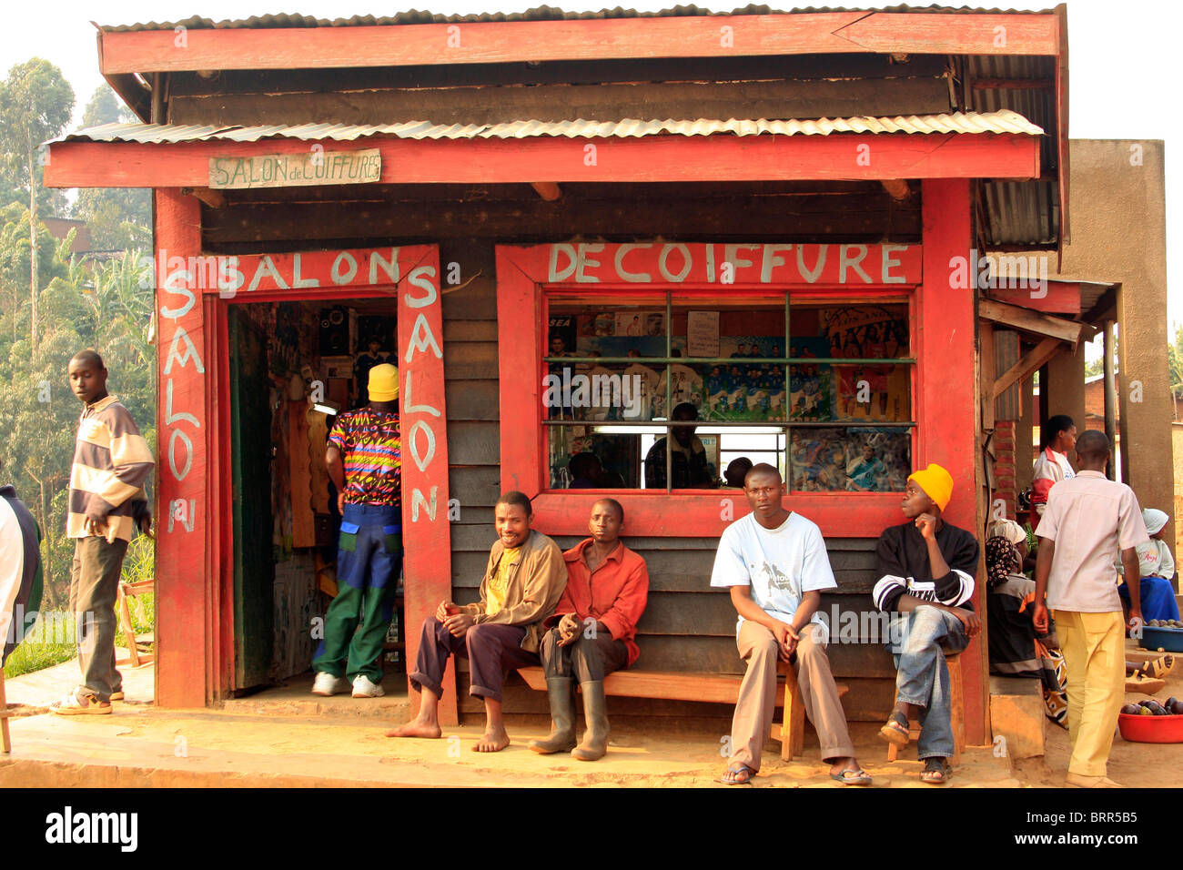 Gruppe von einheimischen Männer sitzen vor einem Friseursalon in Gisankura Dorf Stockfoto