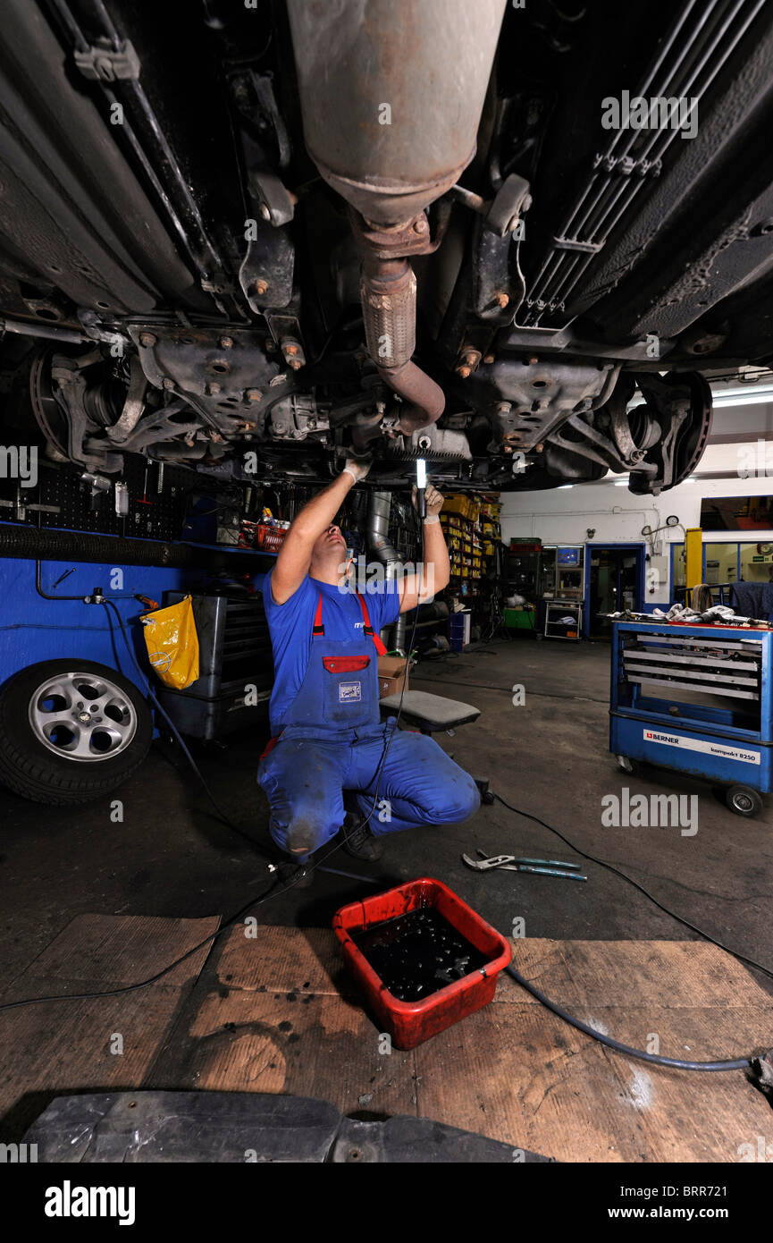 Kfz-Werkstatt mit Mechaniker bei der Arbeit. Stockfoto