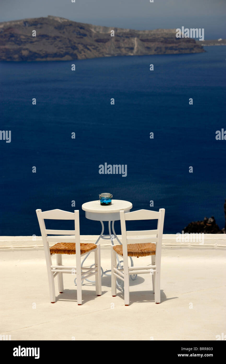 Tisch und Stühle auf dem Dach eines Cafés mit Blick auf die Caldera auf der griechischen Insel Santorini in den Kykladen Stockfoto