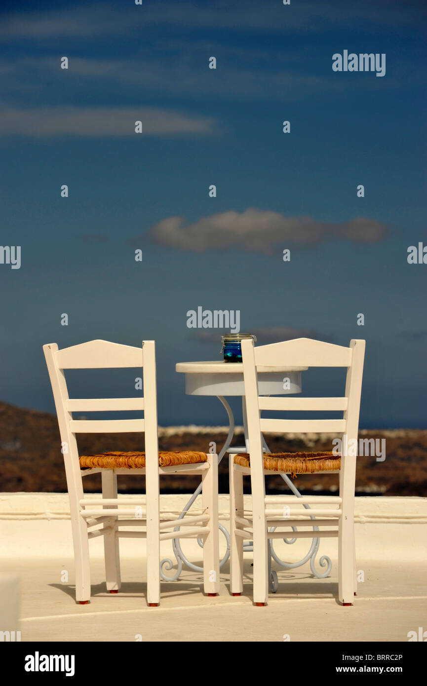 Tisch und Stühle auf dem Dach eines Cafés mit Blick auf die Caldera auf der griechischen Insel Santorini in den Kykladen Stockfoto