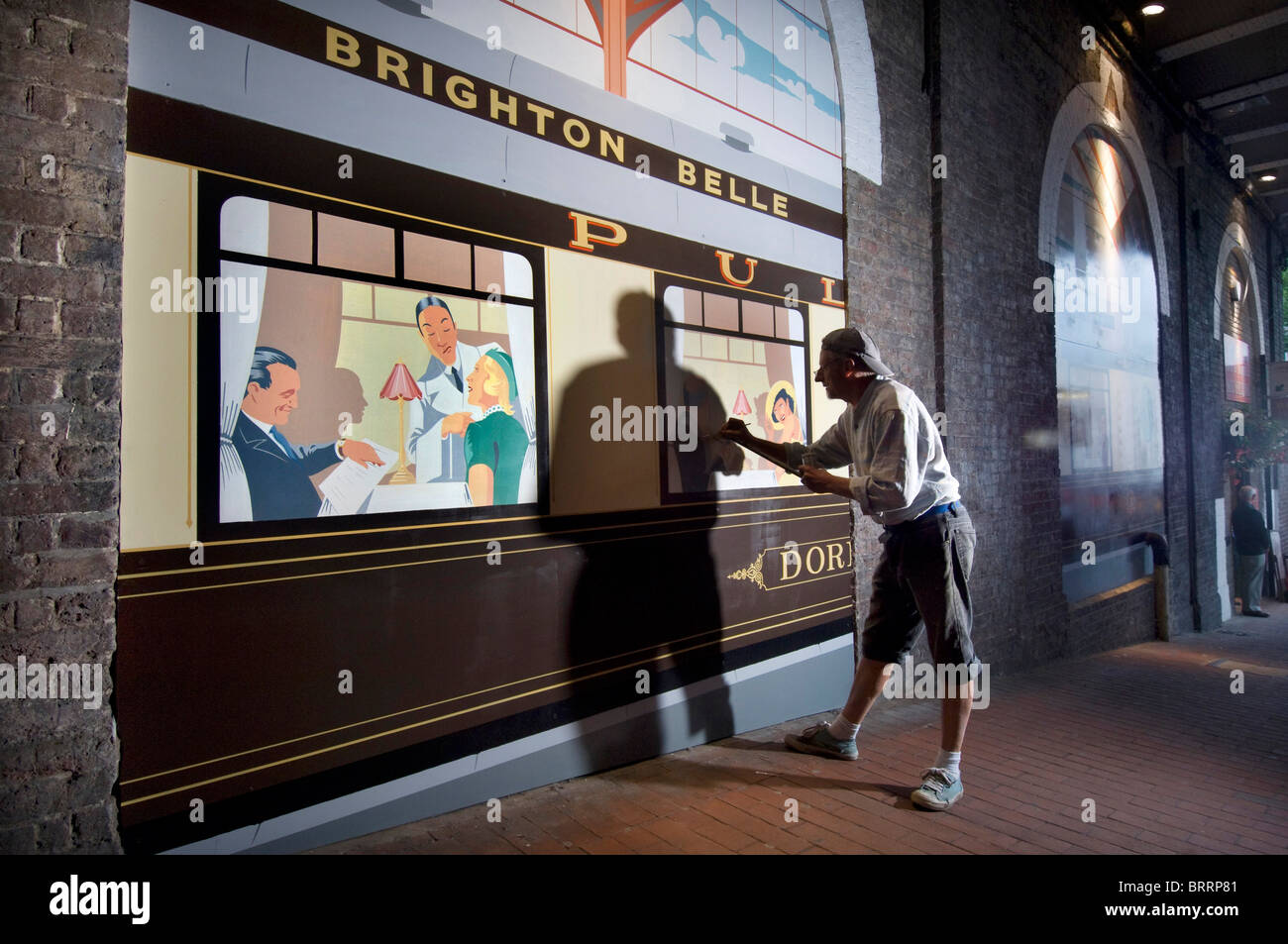 Signwriter Terry Smith malt eine Art-Deco-Stil "Brighton Belle" Eisenbahn Salonwagen "Doris" unter Bahnhof von Brighton. Stockfoto