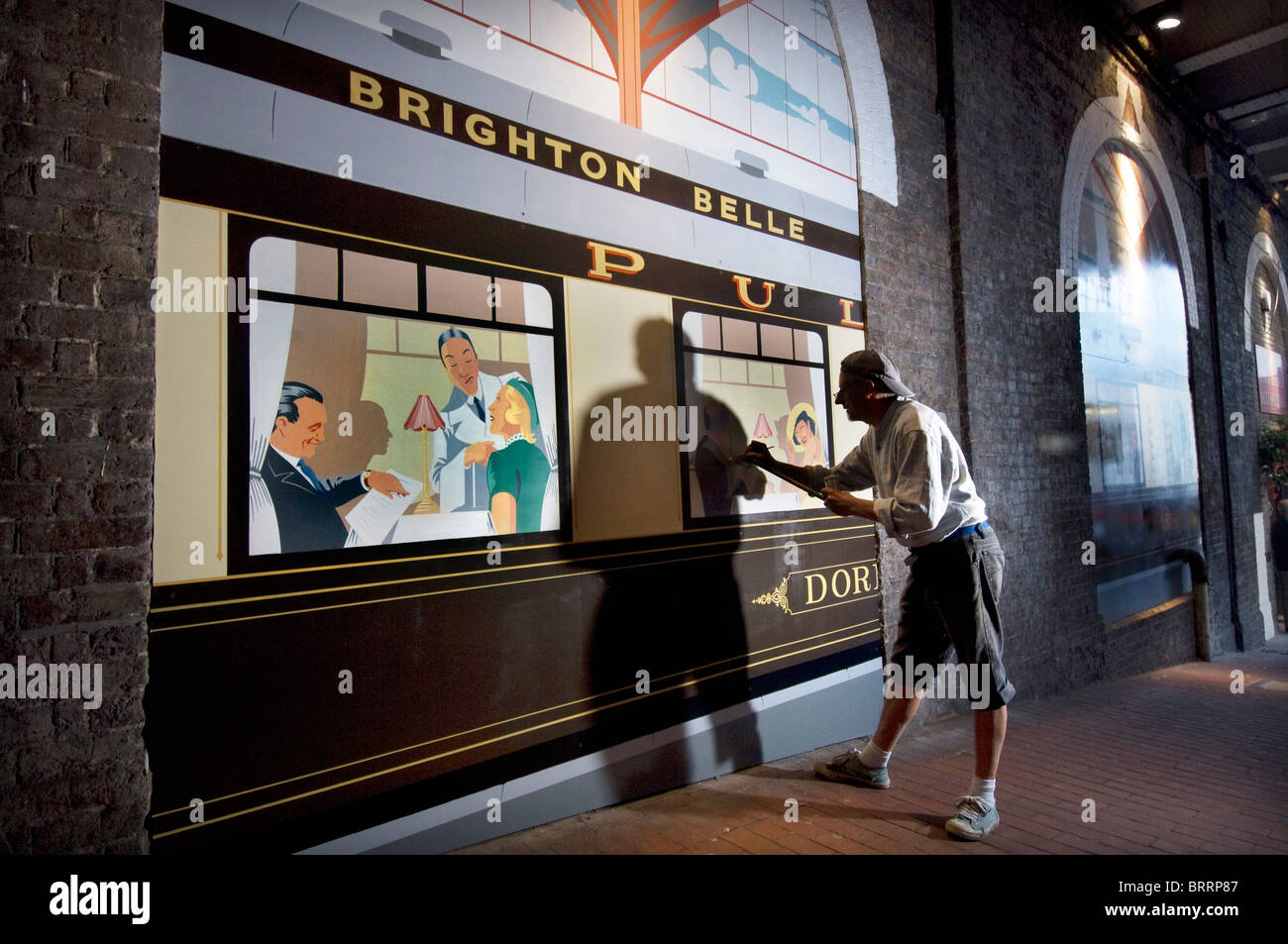 Signwriter Terry Smith malt eine Art-Deco-Stil "Brighton Belle" Eisenbahn Salonwagen "Doris" unter Bahnhof von Brighton. Stockfoto