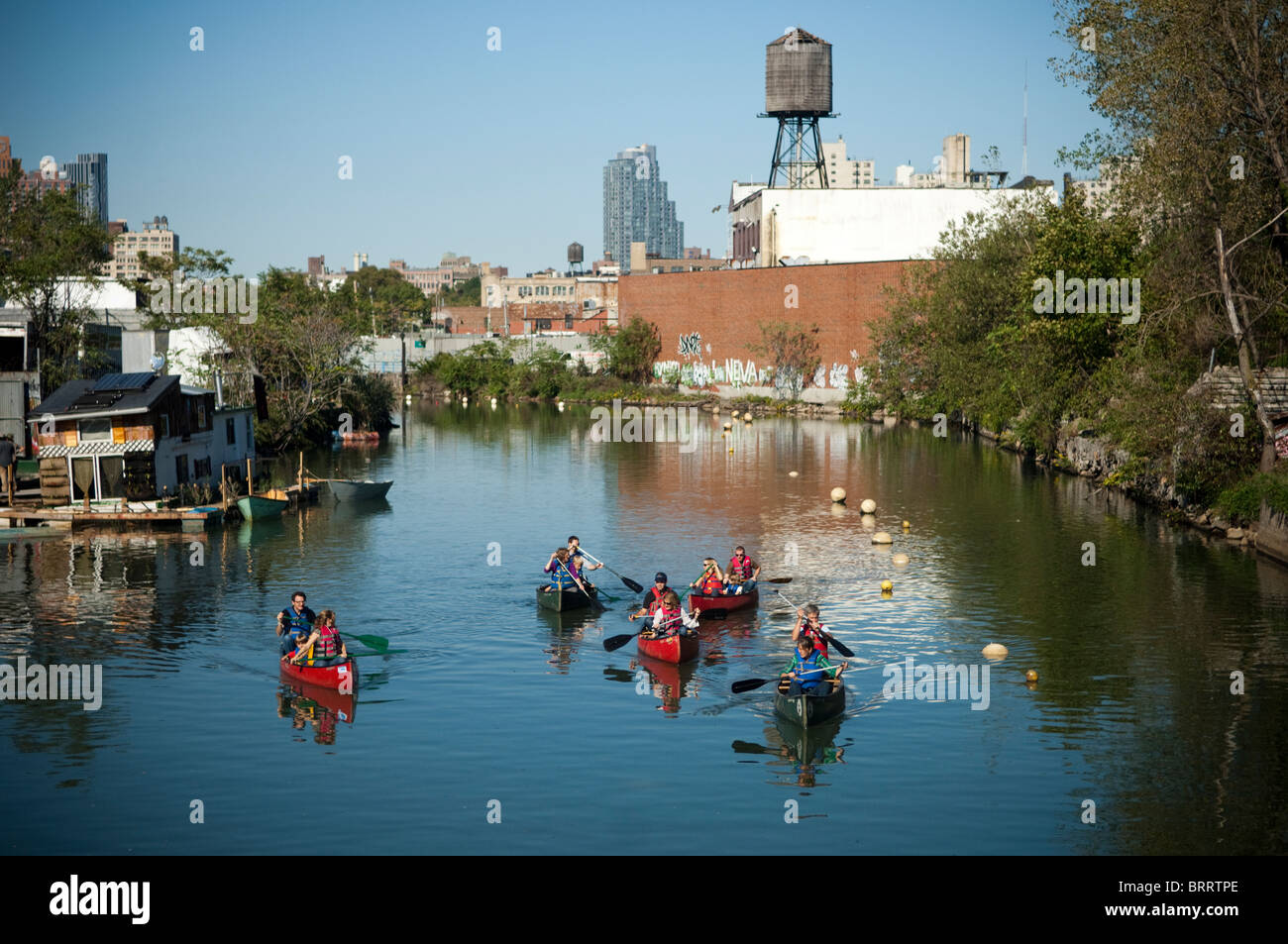 Kanufahrer paddeln verschmutzten Binnenwasserstraßen, die Gowanuskanal. in Brooklyn in New York, Stockfoto