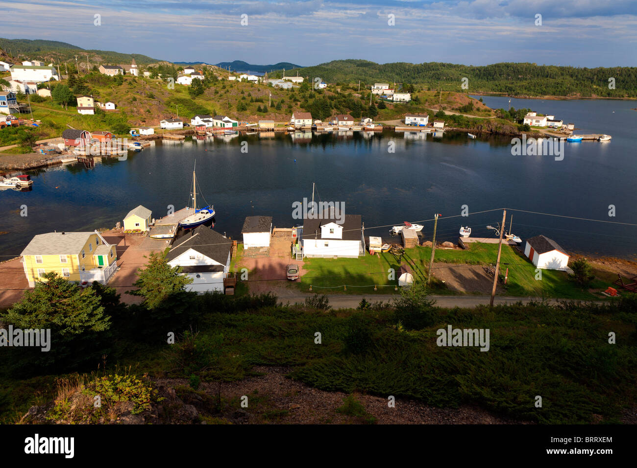 Malerischer Blick auf den Hafen in einer kleinen Bucht mit Fischerdocks, Booten, Stegen und Holzgebäuden auf Pilley's Island, Neufundland, Kanada Stockfoto