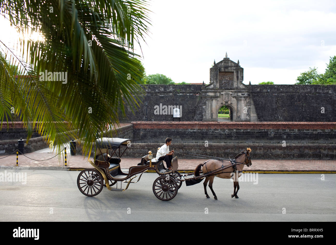 Ein Pferd und Buggy passieren das Haupttor des Fort Santiago im Abschnitt historischen Intramuros Manila auf den Philippinen. Stockfoto