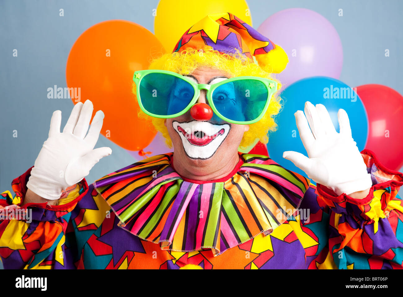 Dumme Clown in übergroßen Gläsern, überrascht Grimasse. Stockfoto