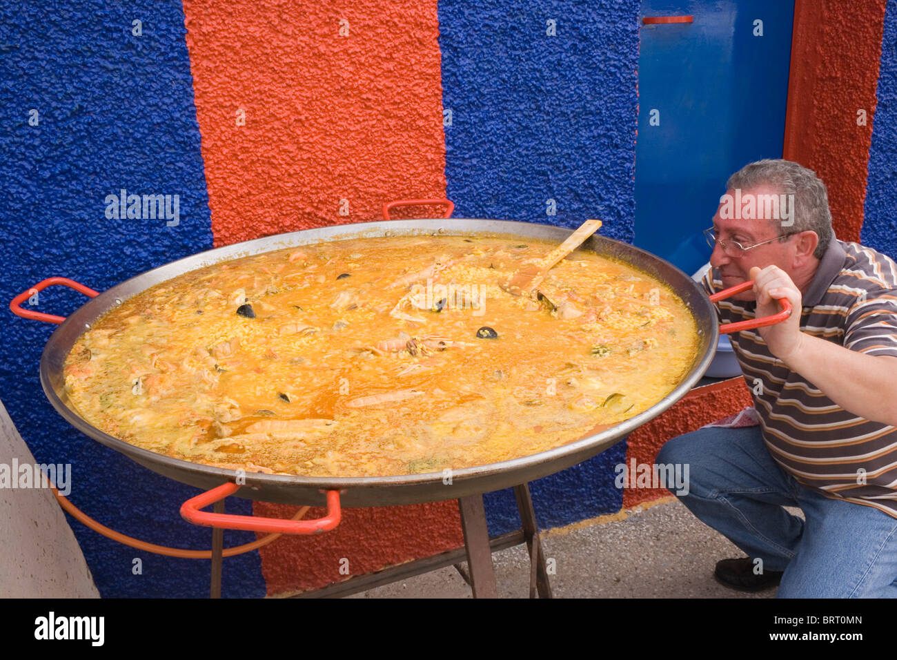Mann kochen große Paella auf dem Festival von Mandel, Almogia Dorf, Provinz Malaga, Malaga, Spanien. Stockfoto