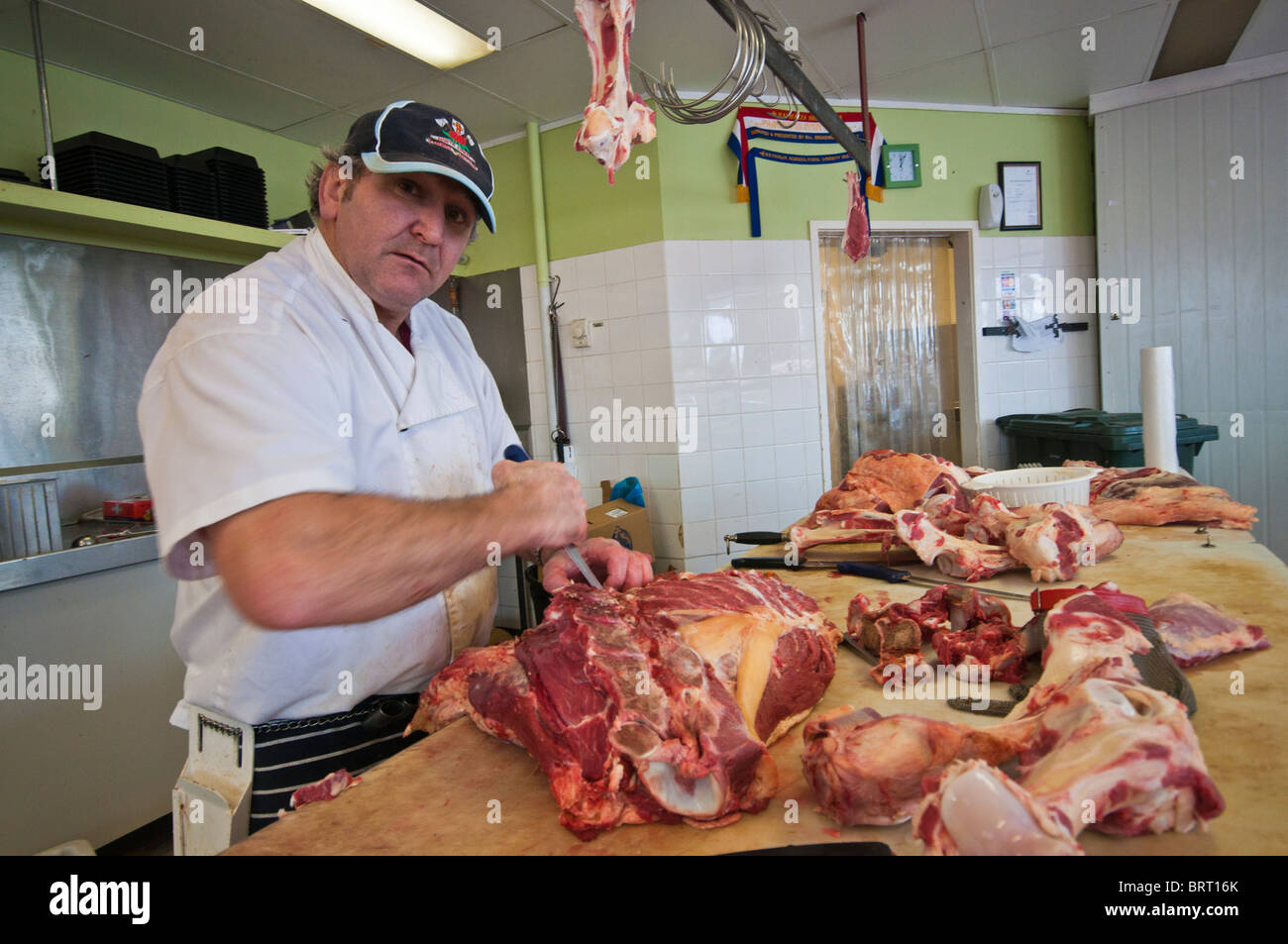 Ein Metzger bei der Arbeit, schneiden Sie Fleisch in seinem Laden in Seymour, Victoria Australien Stockfoto