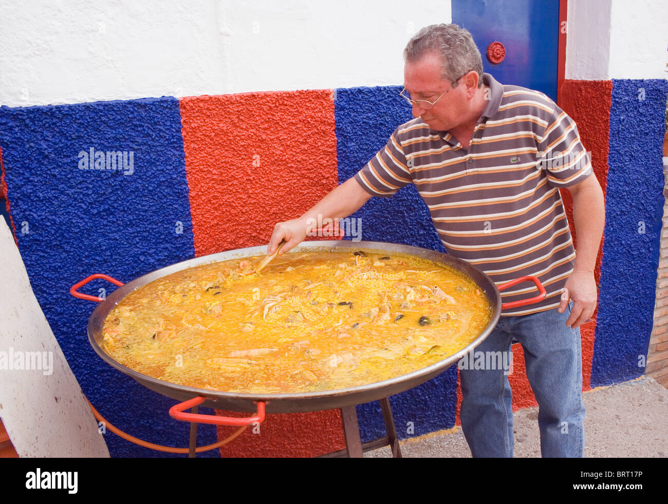 Mann kochen große Paella auf dem Festival von Mandel, Almogia Dorf, Provinz Malaga, Malaga, Spanien. Stockfoto