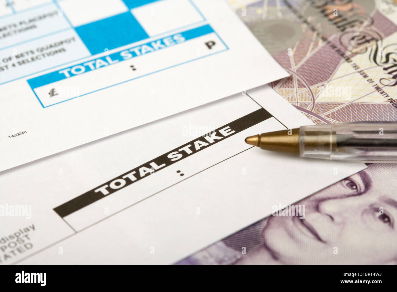 Wettschein aus einem Buchmacher zeigt leere Gesamteinsatz mit Stift und zwanzig Pfund-note Stockfoto