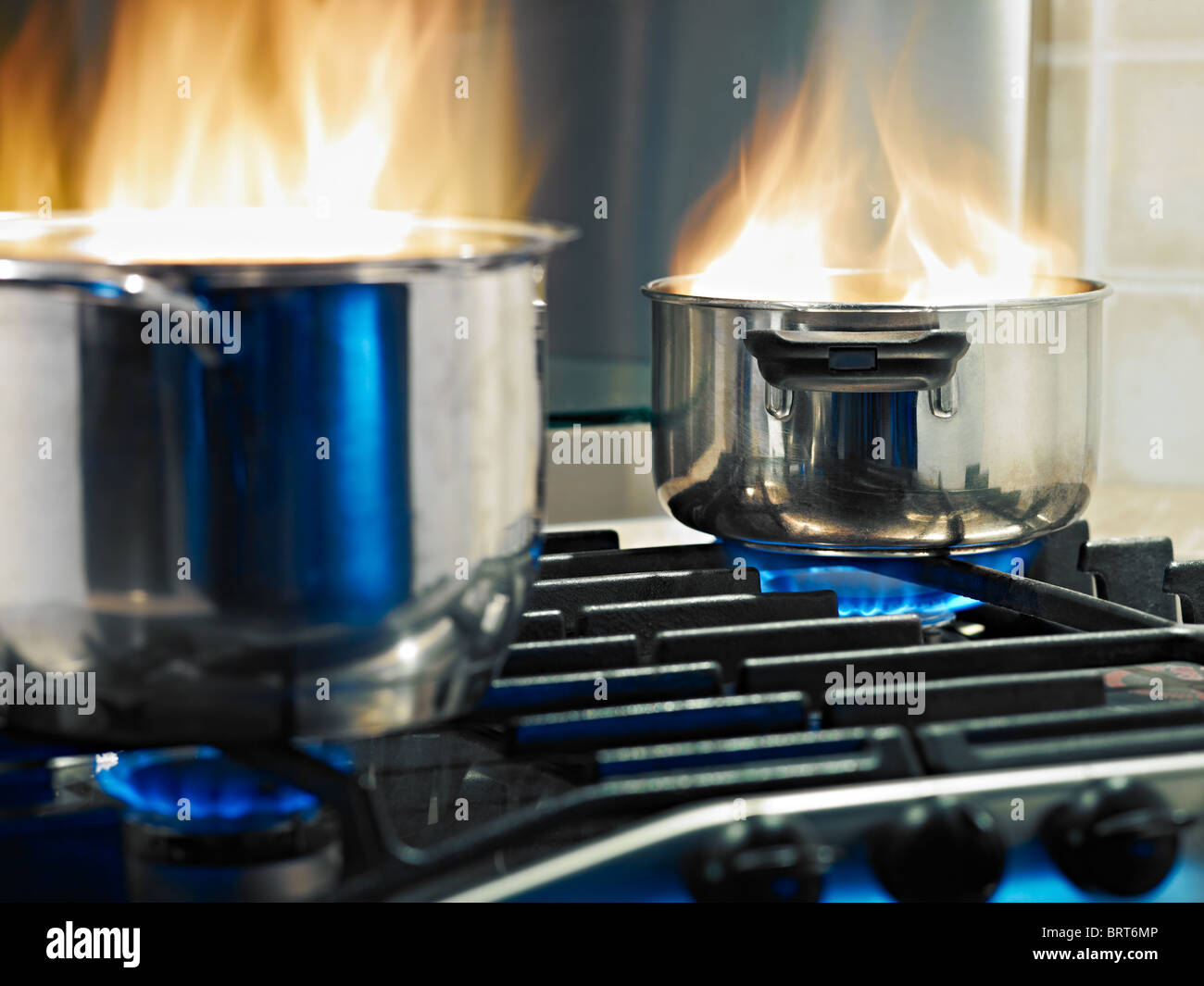 Pfannen in Feuer auf einem Herd. Horizontale Form Stockfoto