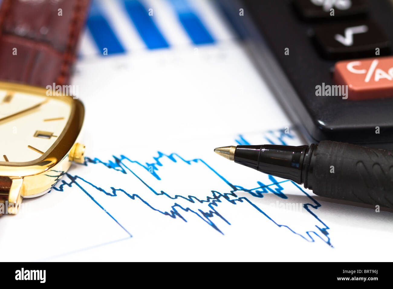 Drucken Sie aus finanziellen Graphen mit einem Taschenrechner, Kugelschreiber und eine Uhr. Stockfoto
