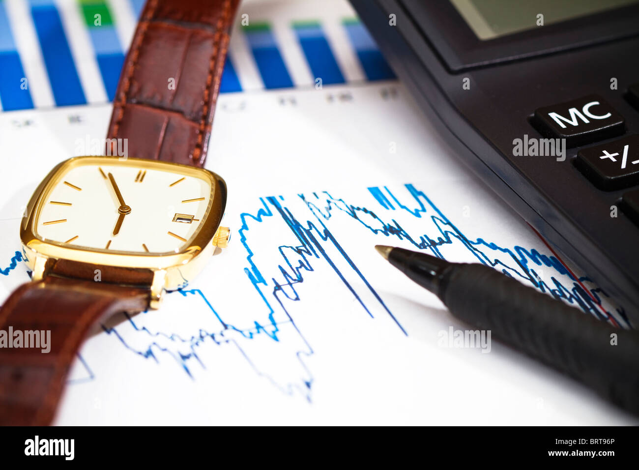 Drucken Sie aus finanziellen Graphen mit einem Taschenrechner, Kugelschreiber und eine Uhr. Stockfoto