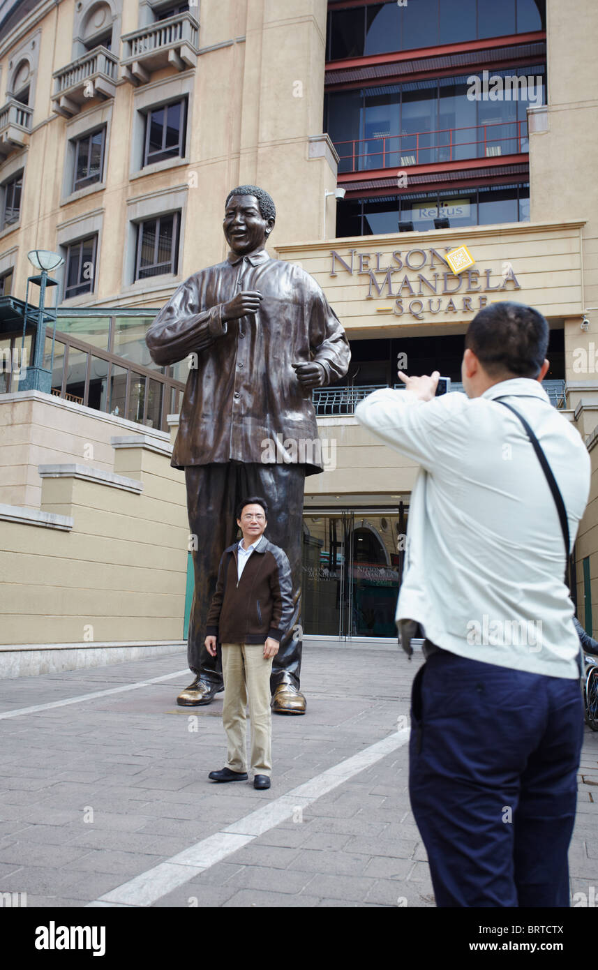 Chinesische Touristen fotografieren vor der Statue von Nelson Mandela, Sandton, Johannesburg, Südafrika Stockfoto