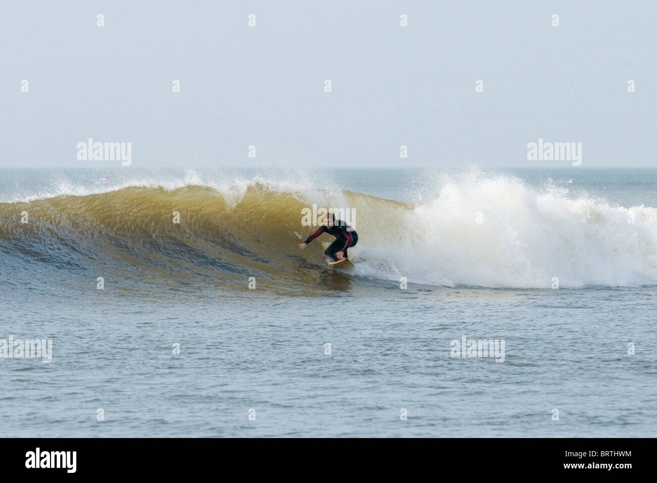 Surfer reiten eine Tonnenverzerrung winken in die "Falle" in Aberystwyth Stockfoto
