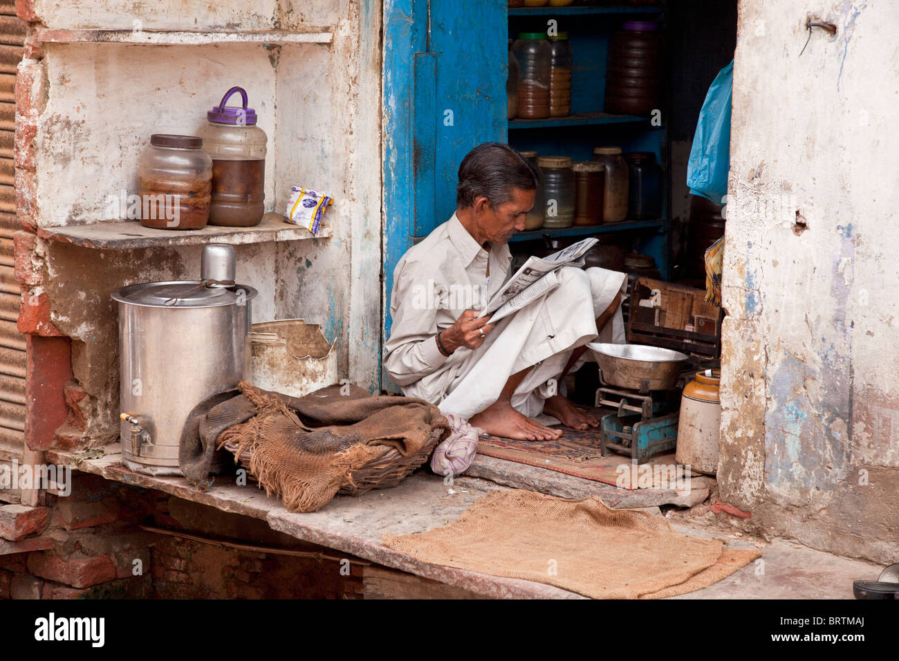 Ein indischer Mann sitzt vor seinem Haus streetside Stockfoto