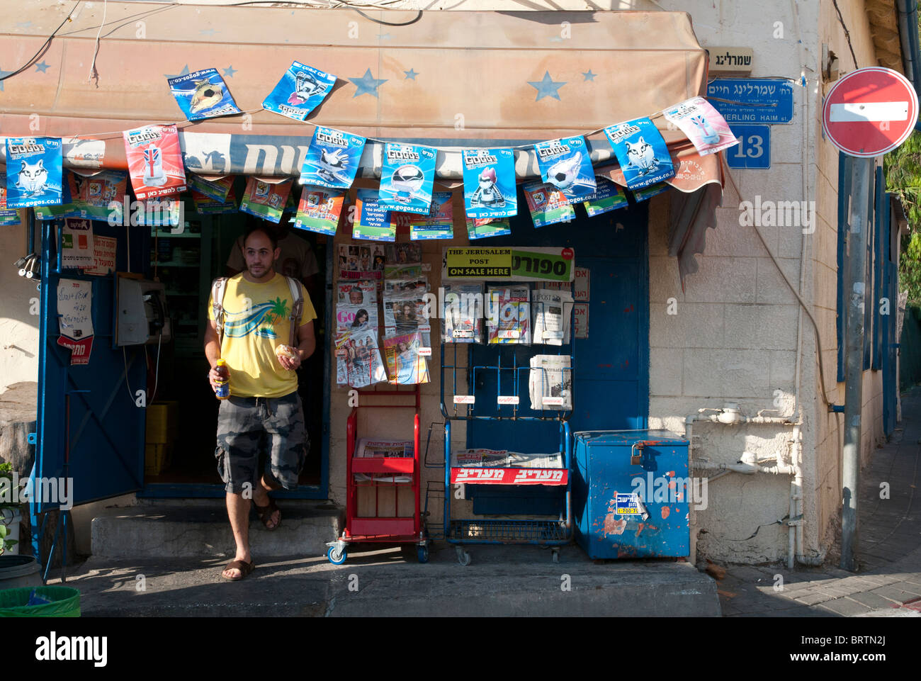 junger Mann aus einem Kiosk in Neve ZEdek, Süd tel Aviv zu treten. Israel Stockfoto