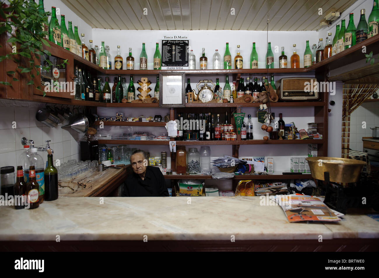 Alte Frau hinter der Theke einer traditionellen kleinen Bar in Alpedrinha, Portugal Stockfoto