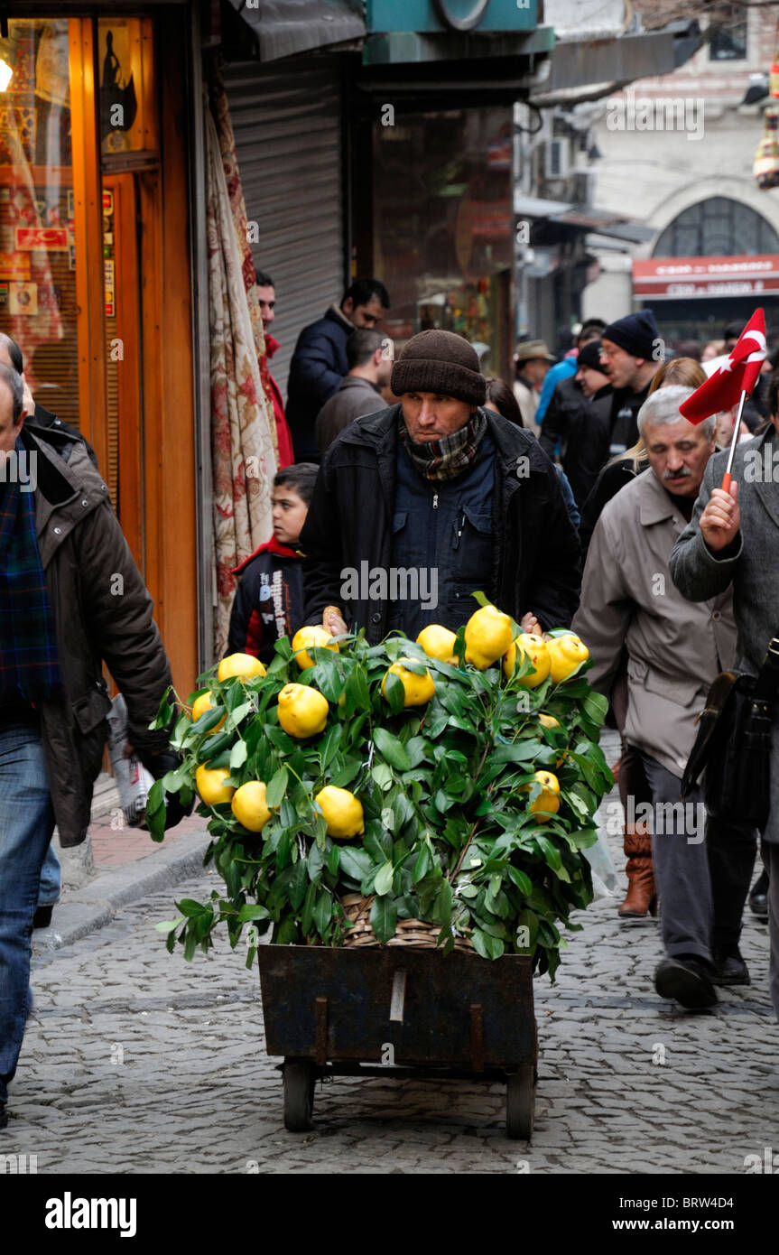 Mann schieben Verkauf Verkauf Trolley Einkaufswagen gefüllt mit gelben Quitten Quitten Frucht Istanbul Türkei Stockfoto