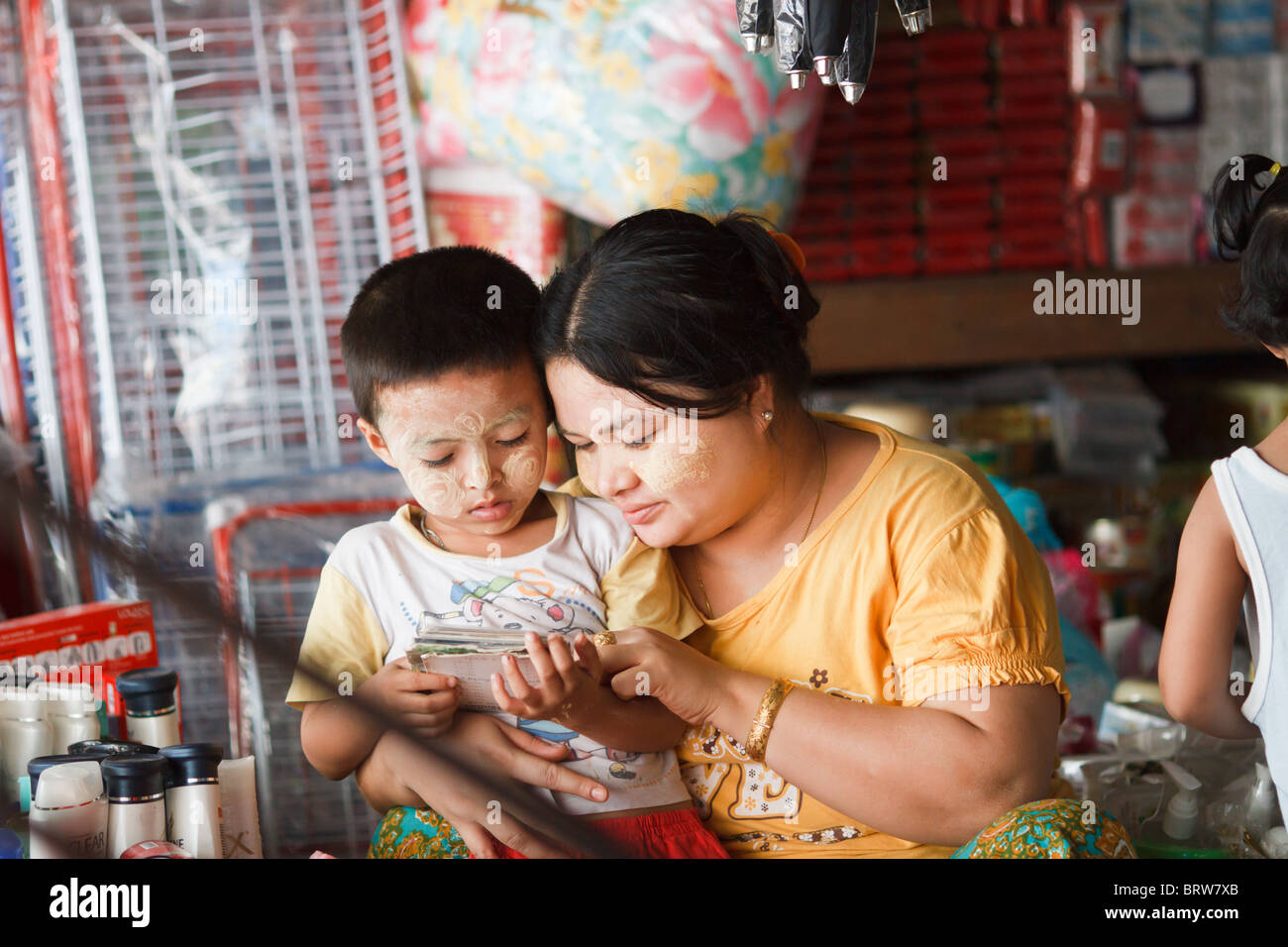 Eine burmesische Frau hilft ihrem Sohn zu lesen, Mae Sot, Thailand Stockfoto