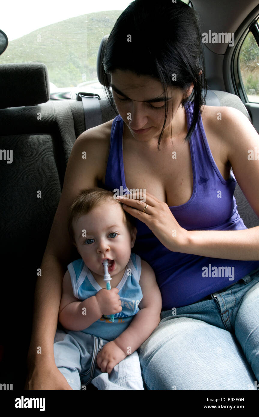 1 Jahr altes Baby mit seiner Mutter auf dem Rücksitz eines Autos Stockfoto