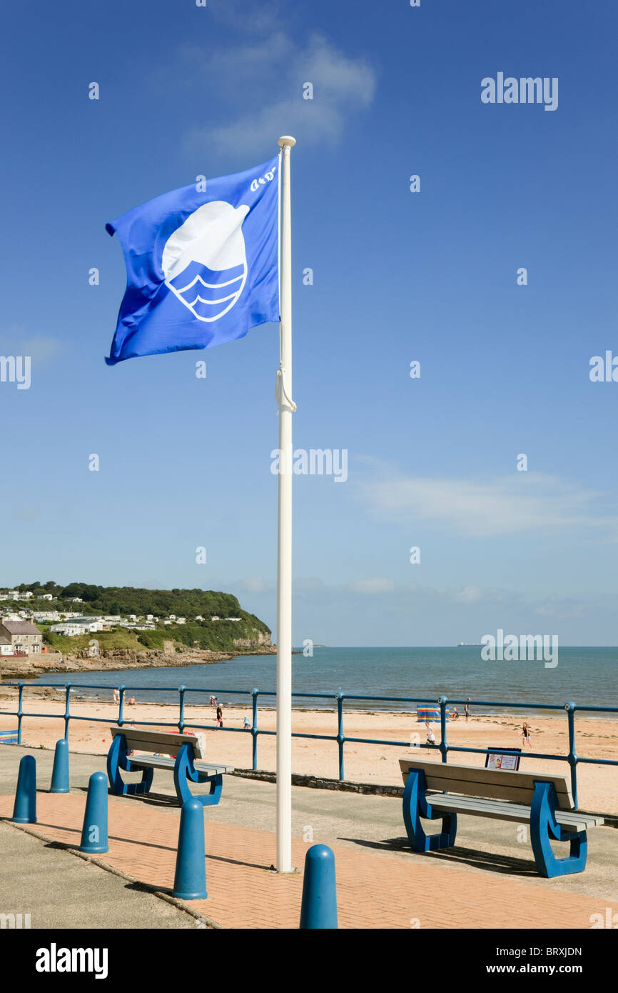 Blaue Flagge an der Strandpromenade mit Blick auf den Strand in Waliser Badeort. Benllech, Isle of Anglesey, North Wales, UK, Großbritannien Stockfoto
