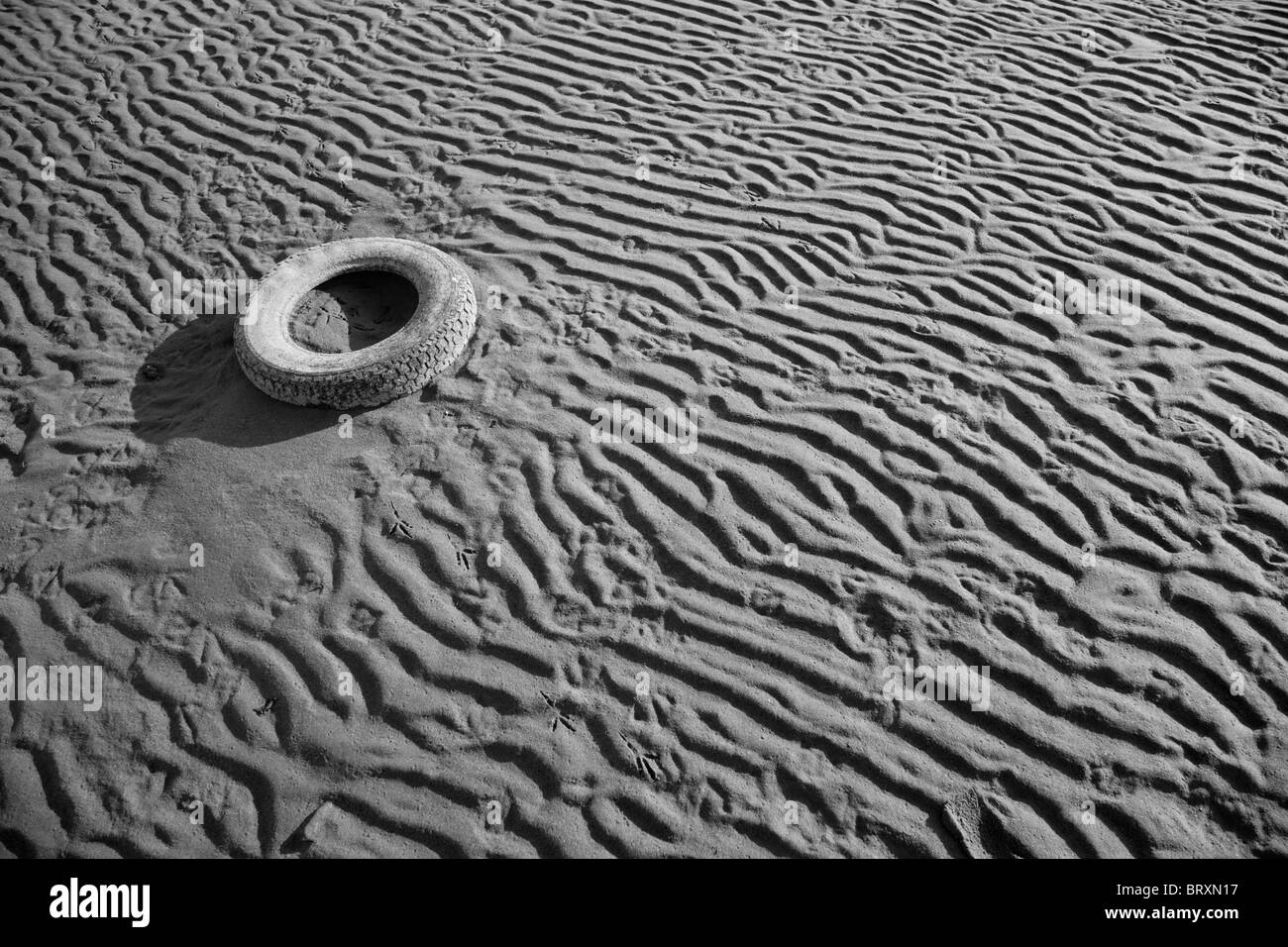 Gebrauchte Autoreifen am Sandstrand Stockfoto