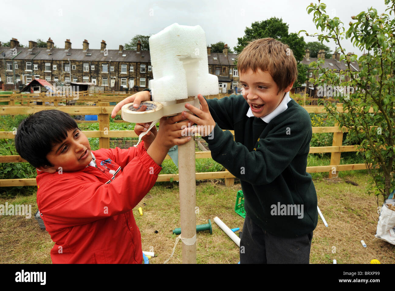 Kinder erstellen Sie Modelle aus Verpackungsabfällen während eines Besuchs in lokalen Kleingärten, Bradford, West Yorkshire Stockfoto