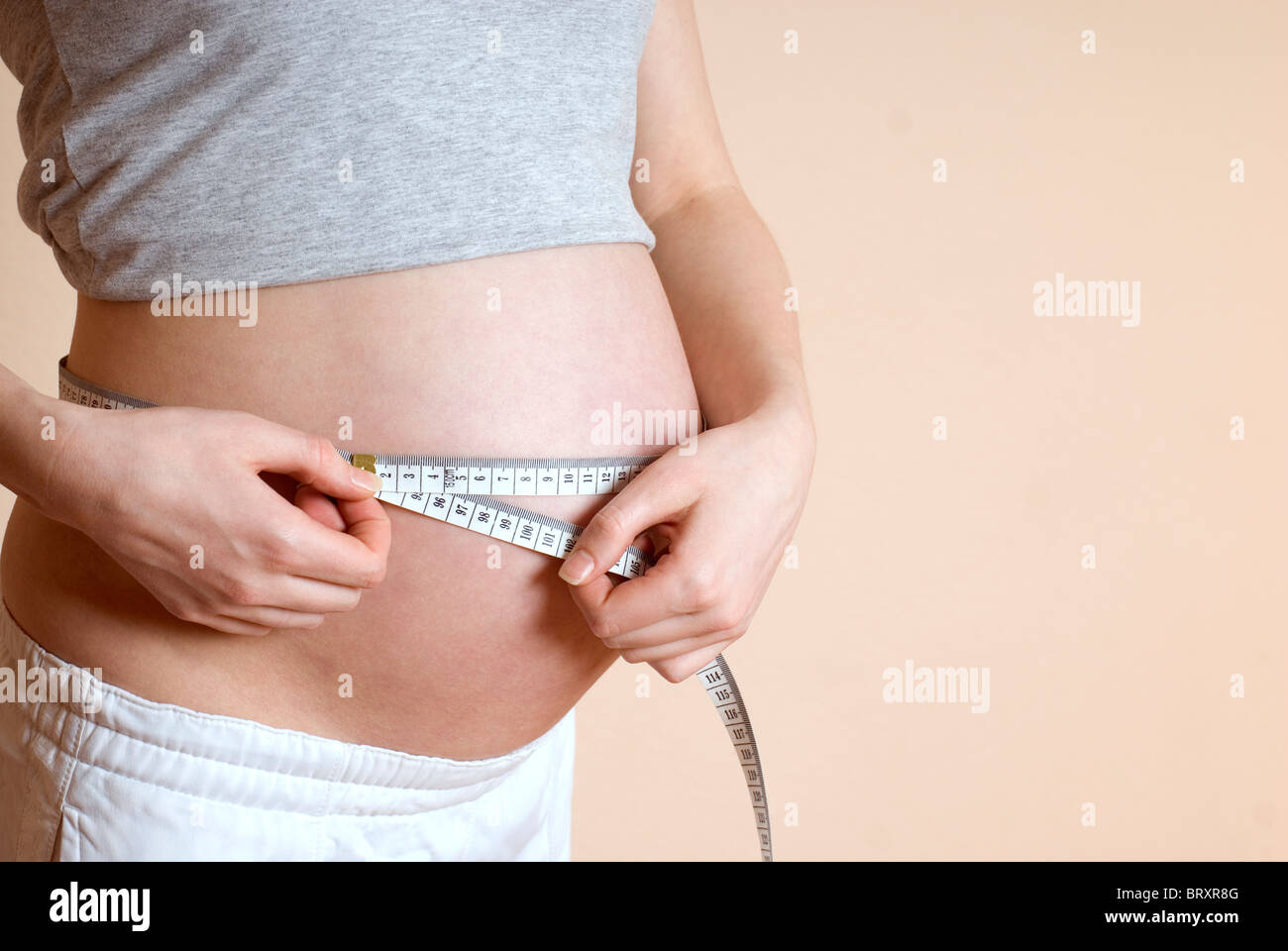 Schwangeren Bauch mit Maßband, Mittelteil messen Stockfoto