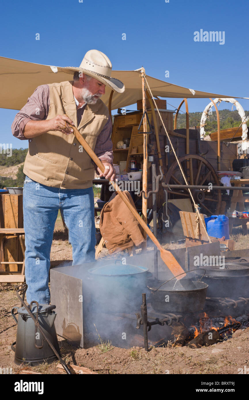 Ein Planwagen Koch rührt den Pott, der Lincoln County Cowboy Symposium und Chuck Wagon Kochwettbewerb, Ruidoso Downs, New Mexico. Stockfoto