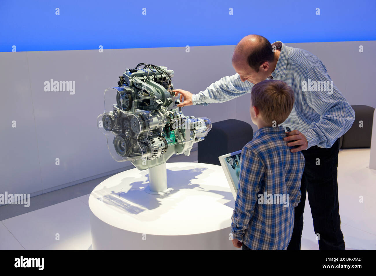Vater Sohn zeigt, wie moderne Automotor arbeitet auf der Paris Motor Show 2010 Stockfoto