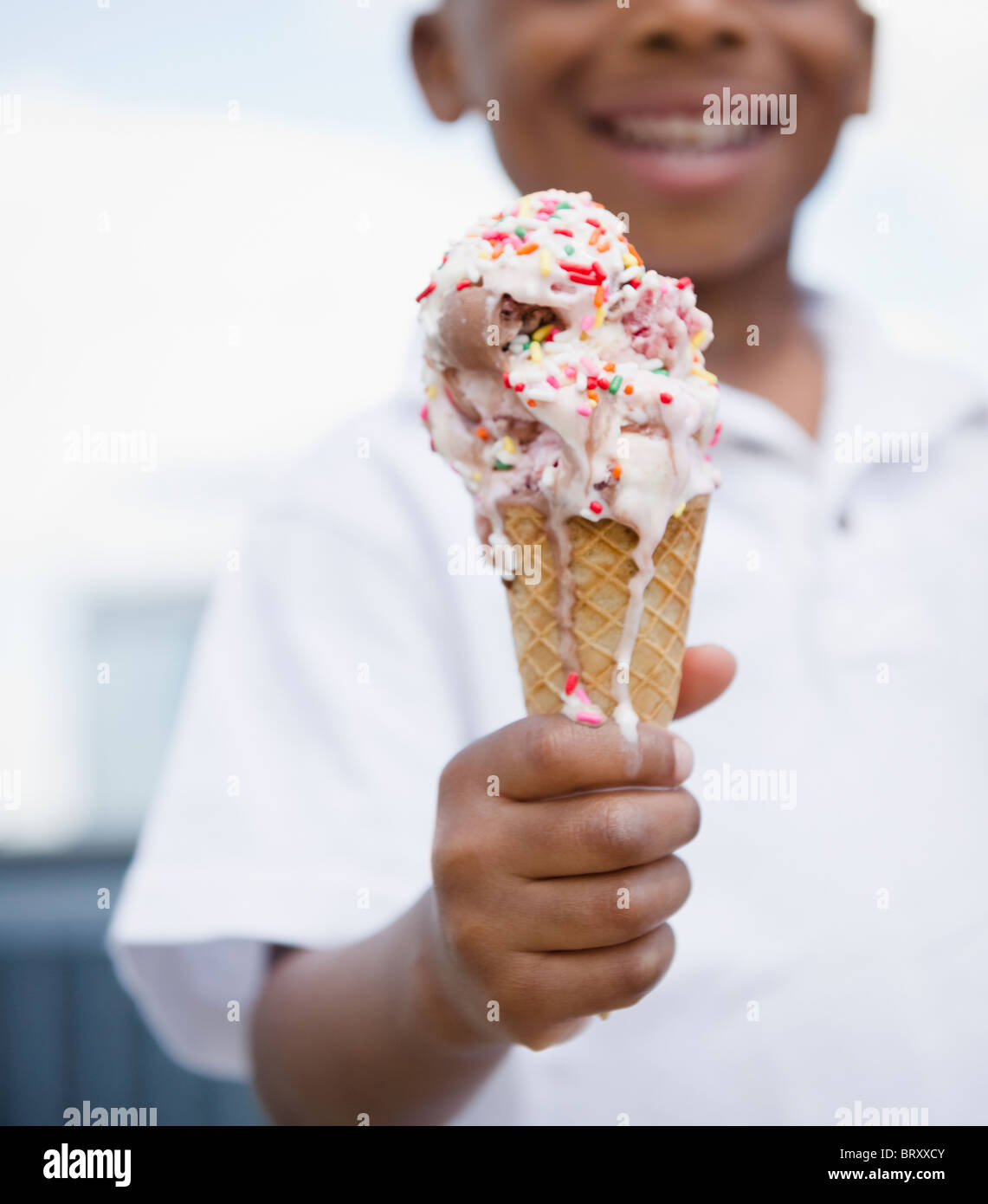 Nahaufnahme eines lächelnden schwarzer Junge mit schmelzendem Eis Stockfoto