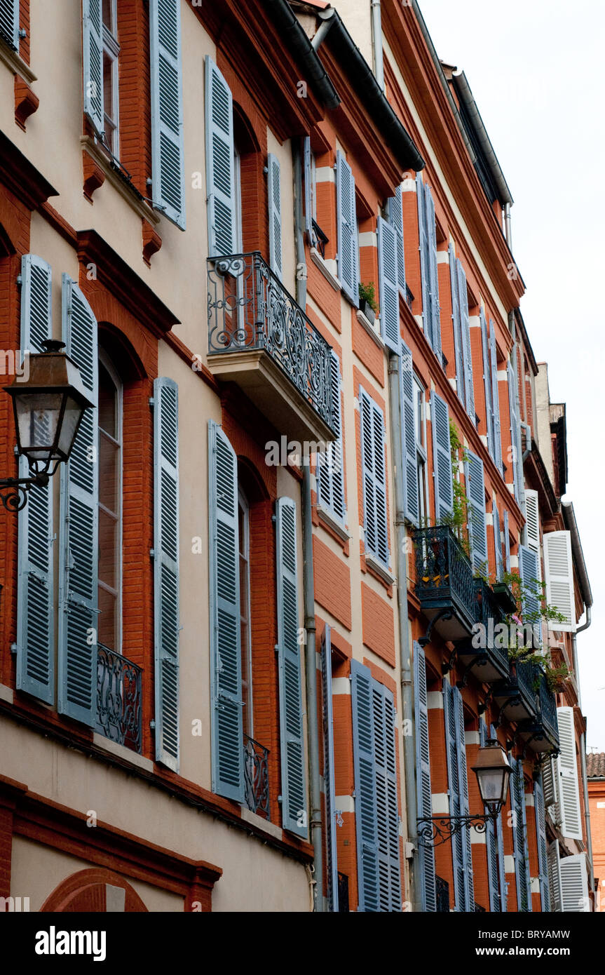 Schöne rote Backsteinhäuser mit weißen Fensterläden auf der Croix-Baragnon Straße, Toulouse, France Stockfoto