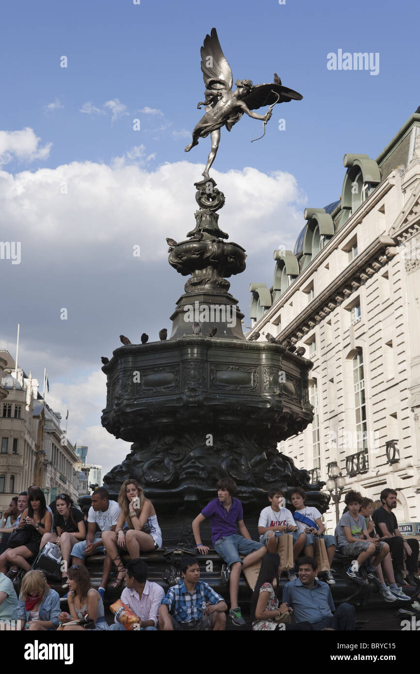 Junge Leute sitzen unter Eros-Statue am Piccadilly Circus, Sommer, London, UK Stockfoto