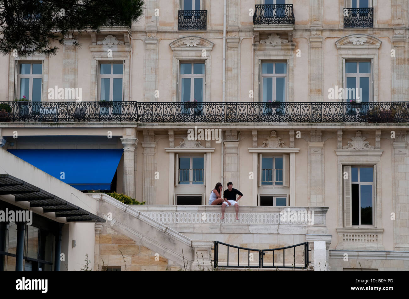 Paar ruht auf der Brüstung eines Hotels an der Strandpromenade Boulevard De La Plage, Arcachon, Frankreich Stockfoto