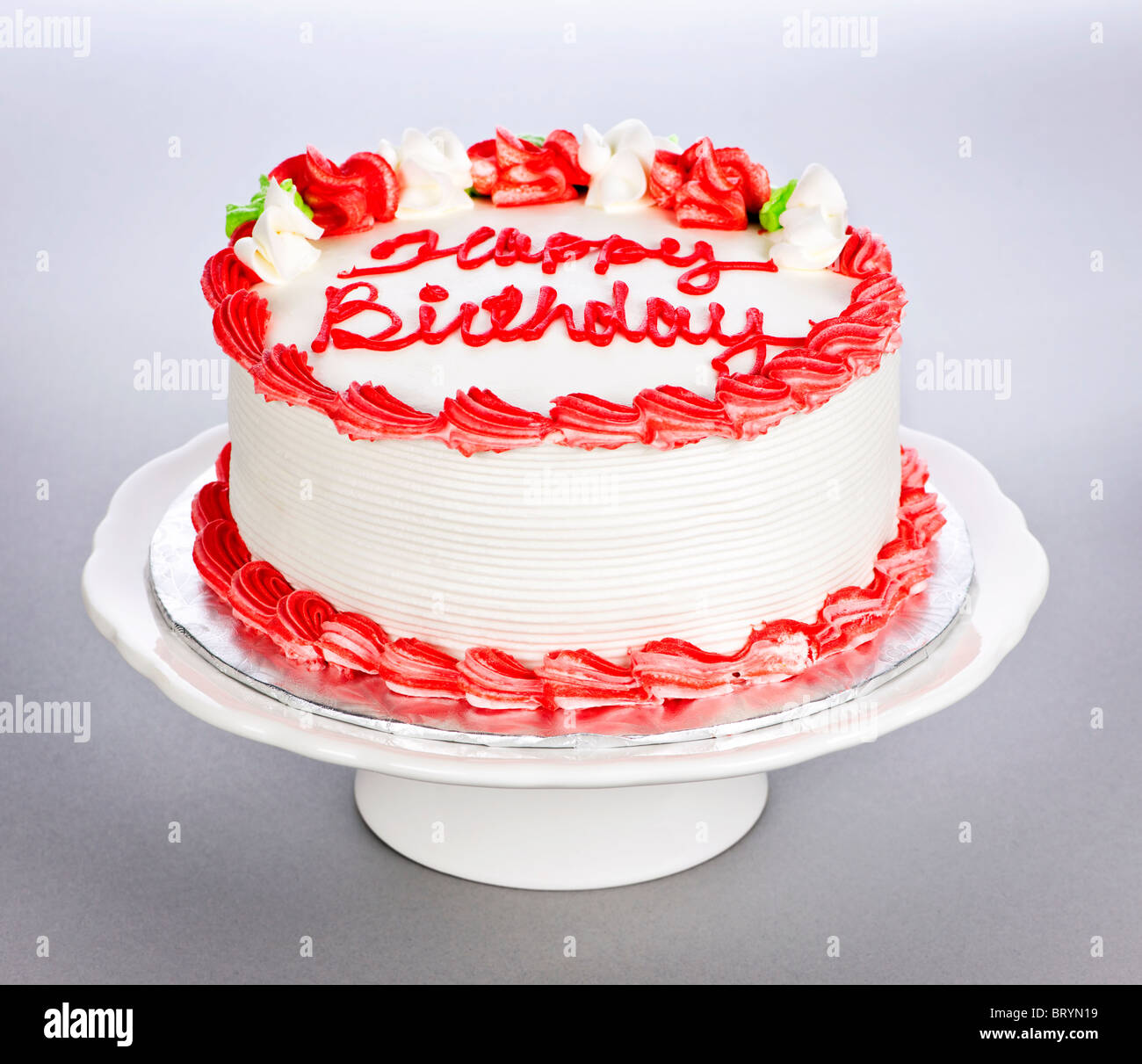 Geburtstagstorte mit weißen und roten Zuckerguss auf Platte Stockfoto