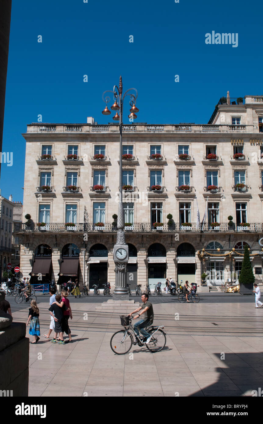 Radfahrer, Uhr und Regent Hotel am Place De La Comedie, Bordeaux, Frankreich Stockfoto