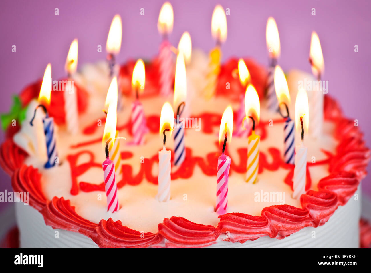 Geburtstagstorte mit brennenden Kerzen und Sahnehäubchen Stockfoto
