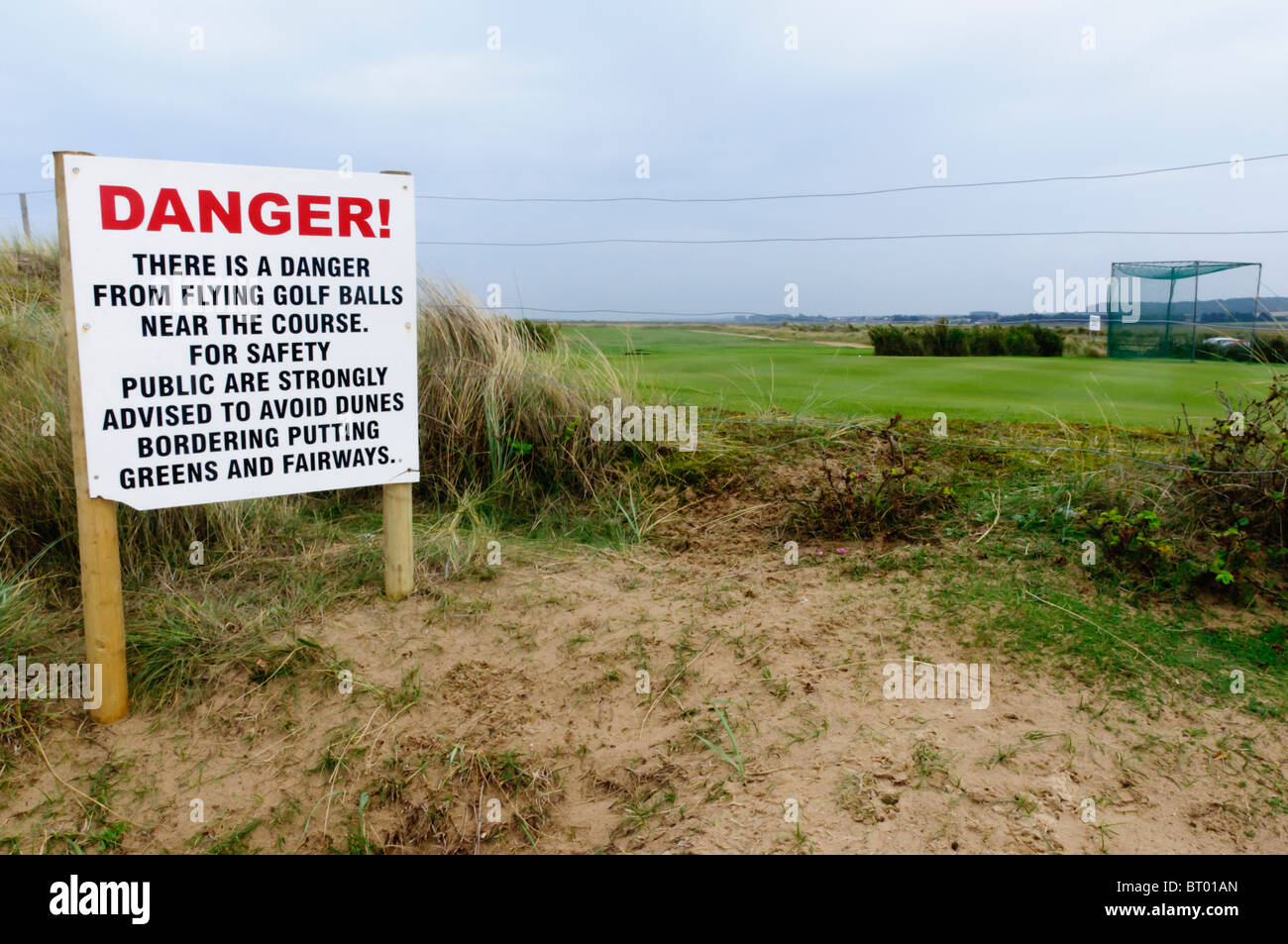 Schild Warnung vor Gefahr durch fliegende Golfbälle Brancaster Golfplatz in Norfolk, England Stockfoto