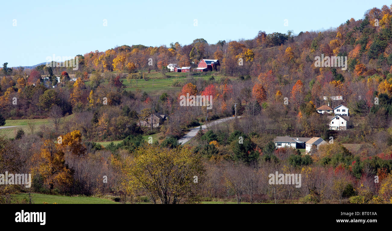 Eine Farm auf einem Hügel mit einigen privaten Häusern umgeben. Gedreht im Herbst in den Bergen von New York USA. Stockfoto