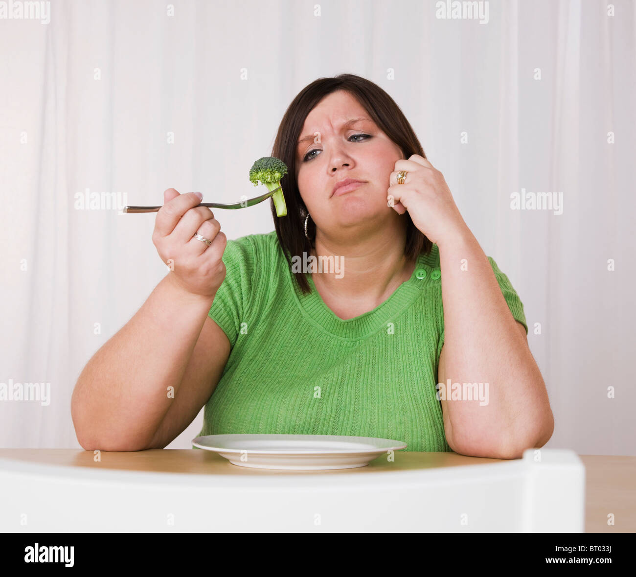 Übergewichtige junge Frau Brokkoli essen Stockfoto