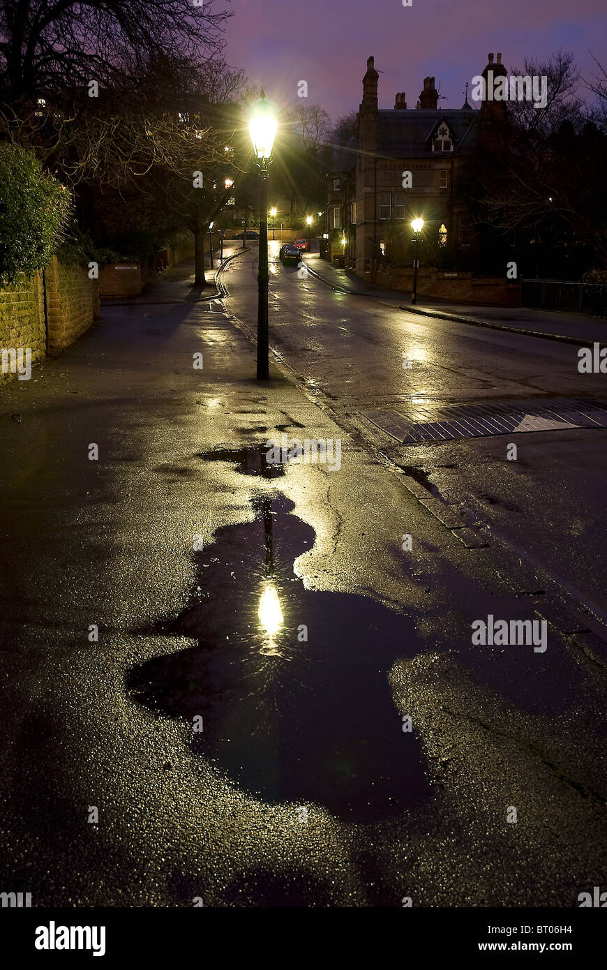 Eine nasse viktorianischen oder edwardianischen Straße in der Nacht von Gaslampen beleuchtet Stockfoto