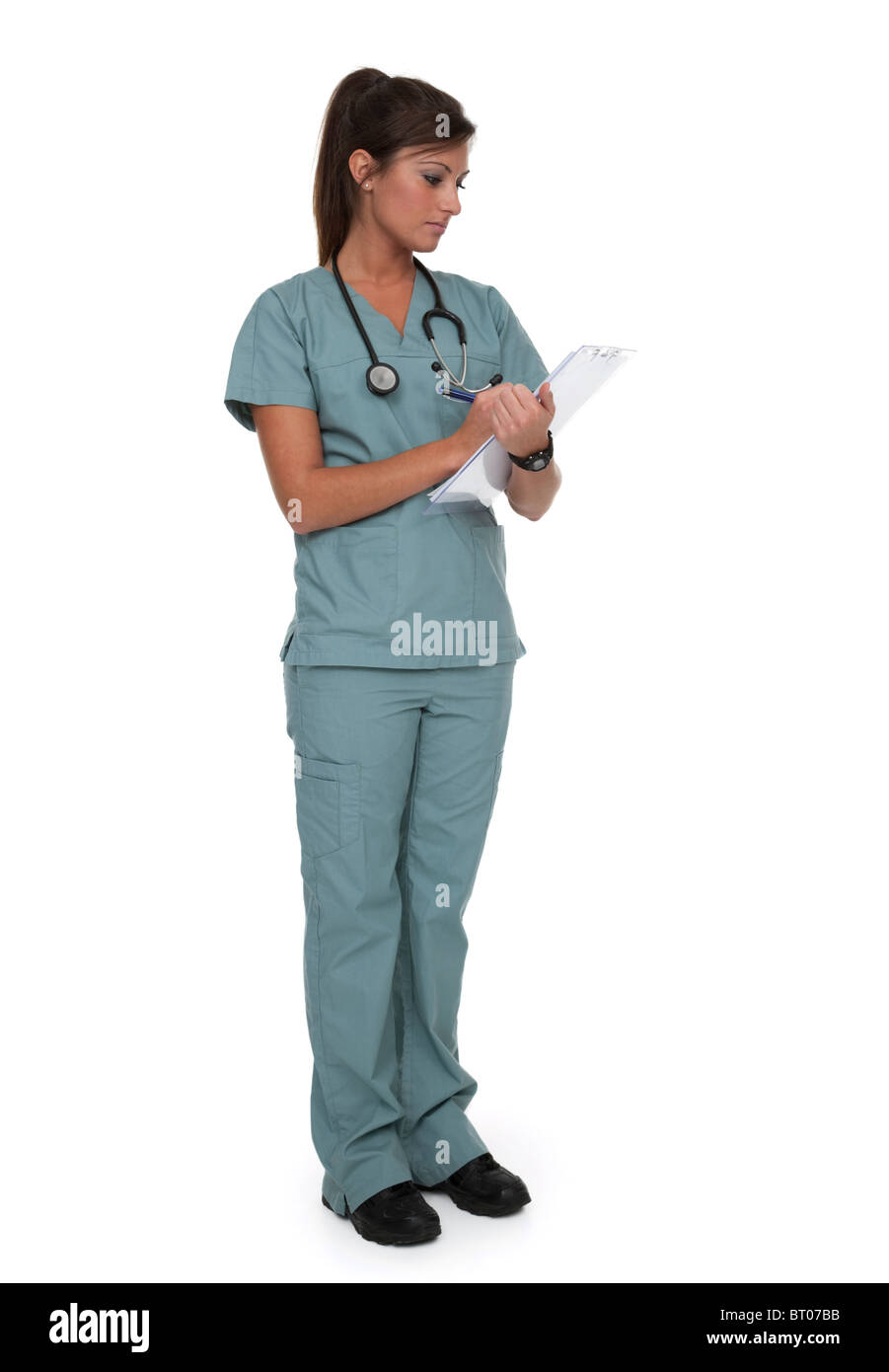 Voller Länge Foto ziemlich Gesundheitswesen Arbeitnehmerin dressed in Scrubs auf weißem Hintergrund. Stockfoto