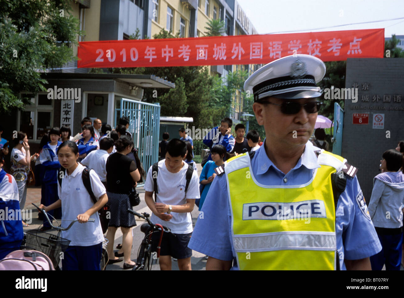 Polizisten patrouillieren während Studenten einer Schule nach der Teilnahme an Senior high school Aufnahmeprüfung in Peking, China. Stockfoto