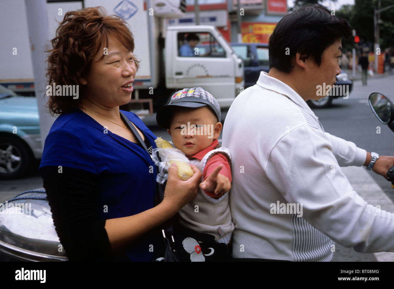 Ein kleiner Junge auf einem Elektrofahrrad mit seinen Familienmitgliedern in Shanghai, China.  2009 Stockfoto