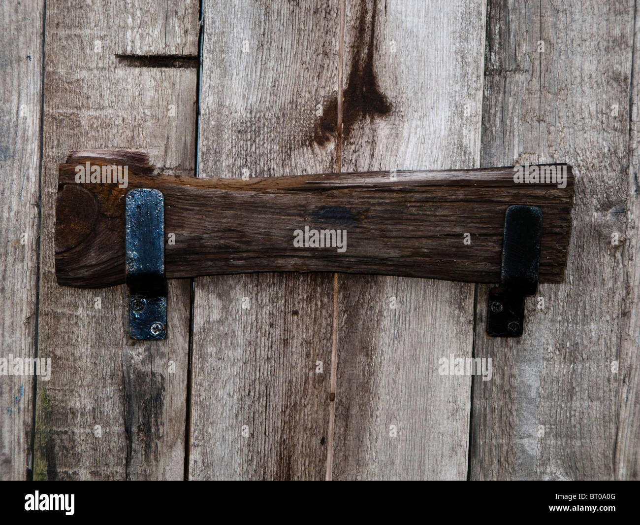 Fensterläden aus Holz mit einem hölzernen Schlagstock gesichert und Metall-Laschen Stockfoto