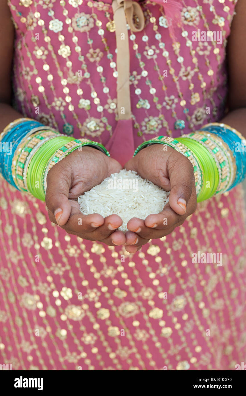 Indisches Mädchen Holding ungekochter Reis in ihren hohlen Händen. Indien Stockfoto