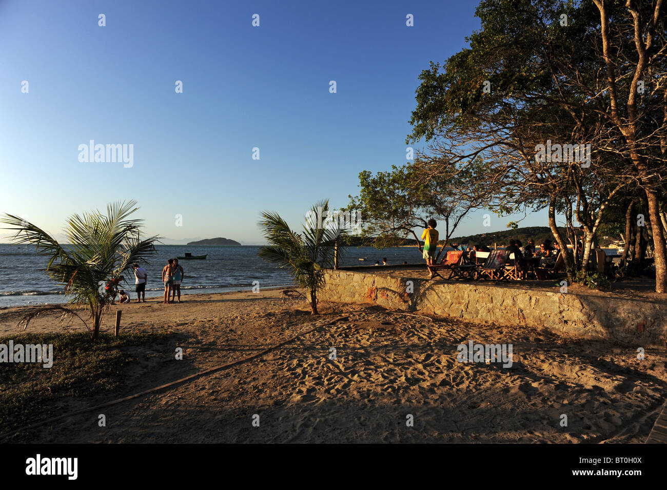 Menschen versammeln, um den Sonnenuntergang am Manguinhos Strand von Buzios Stockfoto