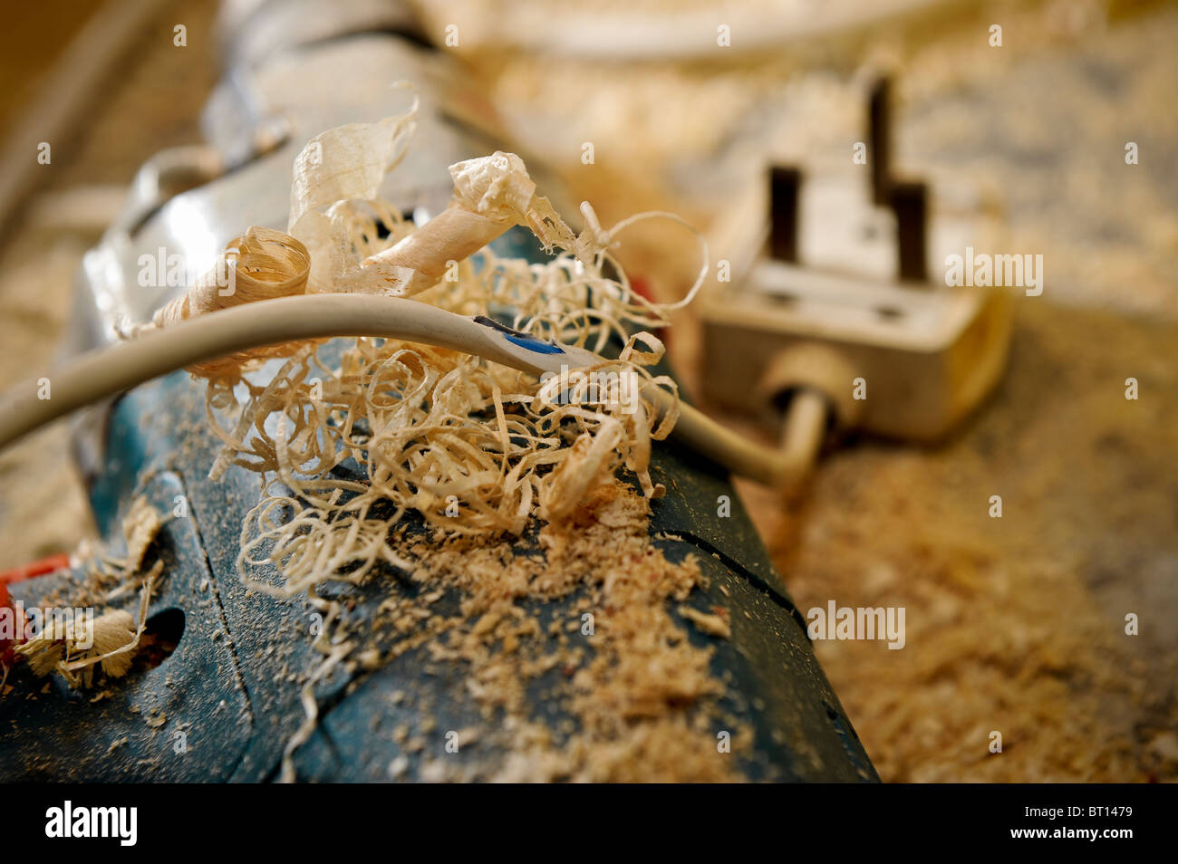ein gefährliches Feuer-Risiko mit einem elektrischen Kabel auf eine Bohrmaschine mit brennbaren Materialien umgeben Stockfoto