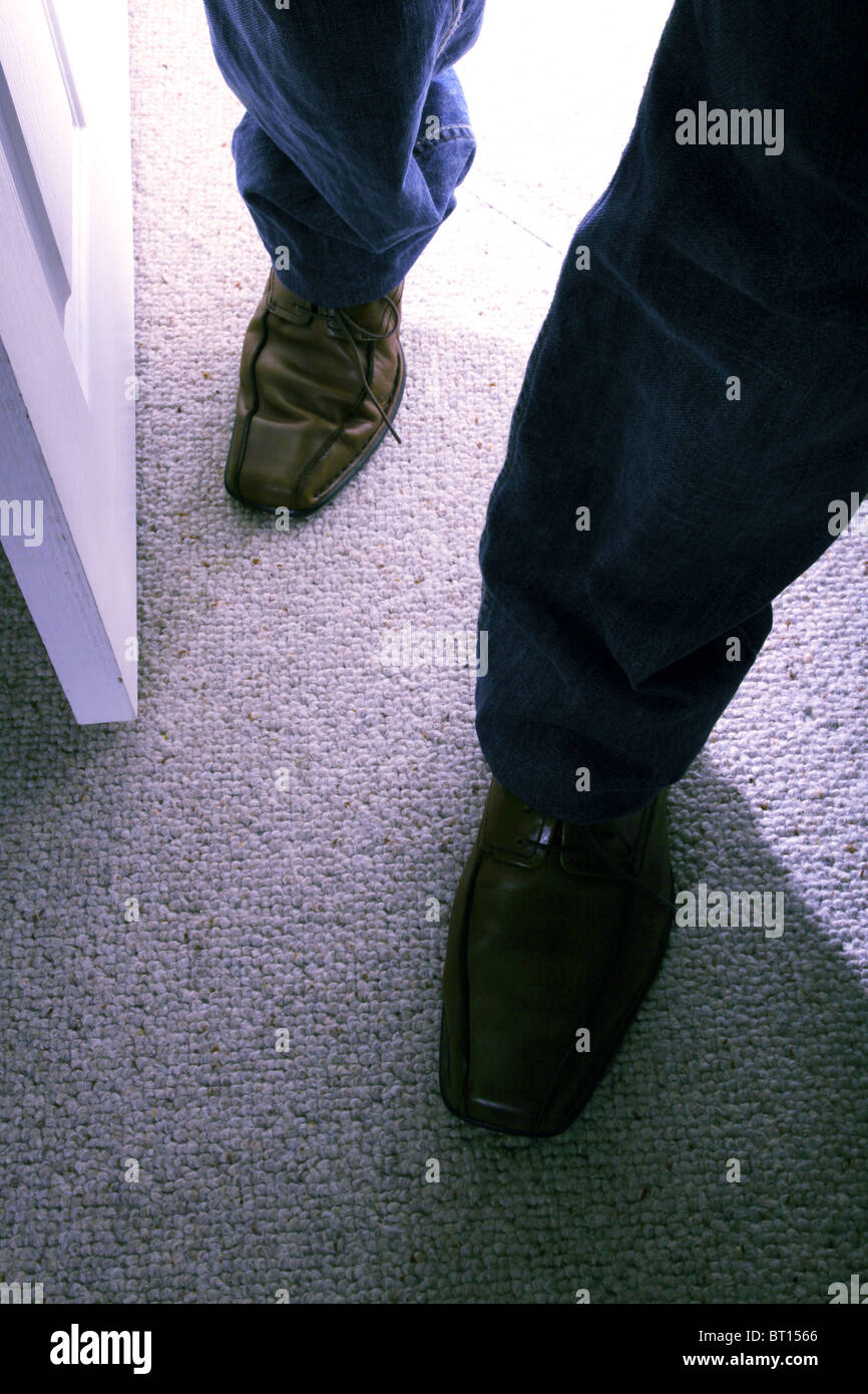 Mann geht in einen Raum trägt braune Schuhe und jeans Stockfoto